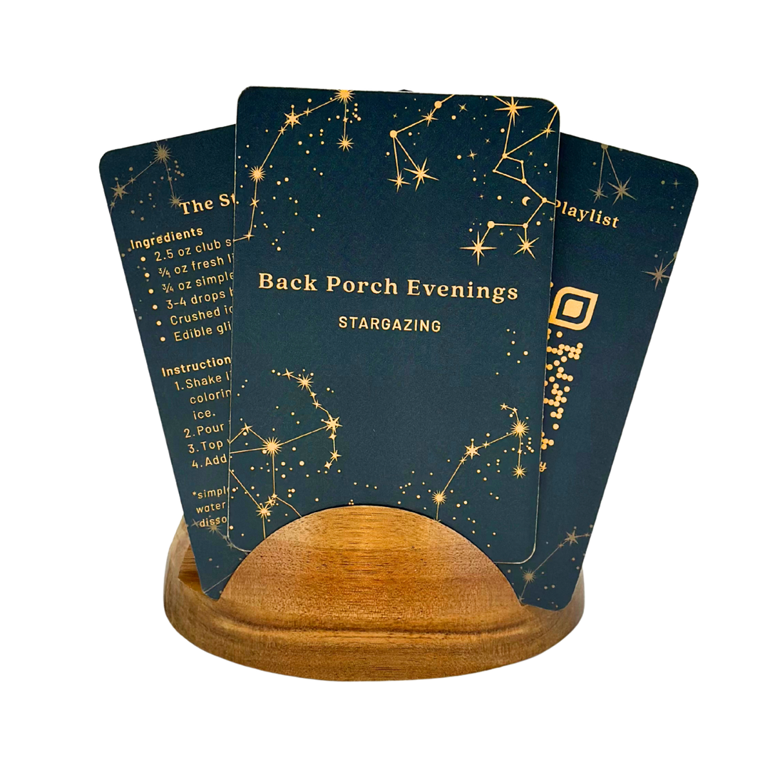 Three star-themed, Back Porch Evenings Guide cards on a wooden stand with celestial designs and text.